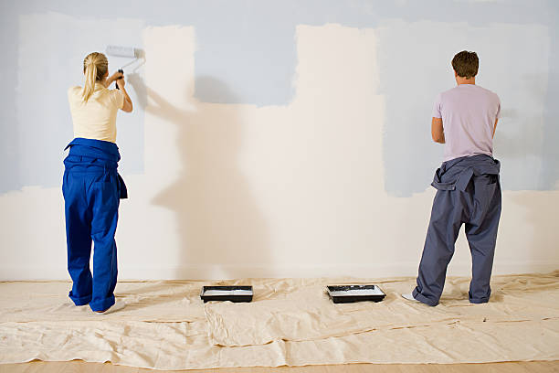 Jeune couple qui repeint les murs de son appartement